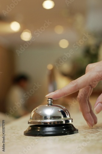 Businesswoman ringing desktop bell at the reception counter. photo