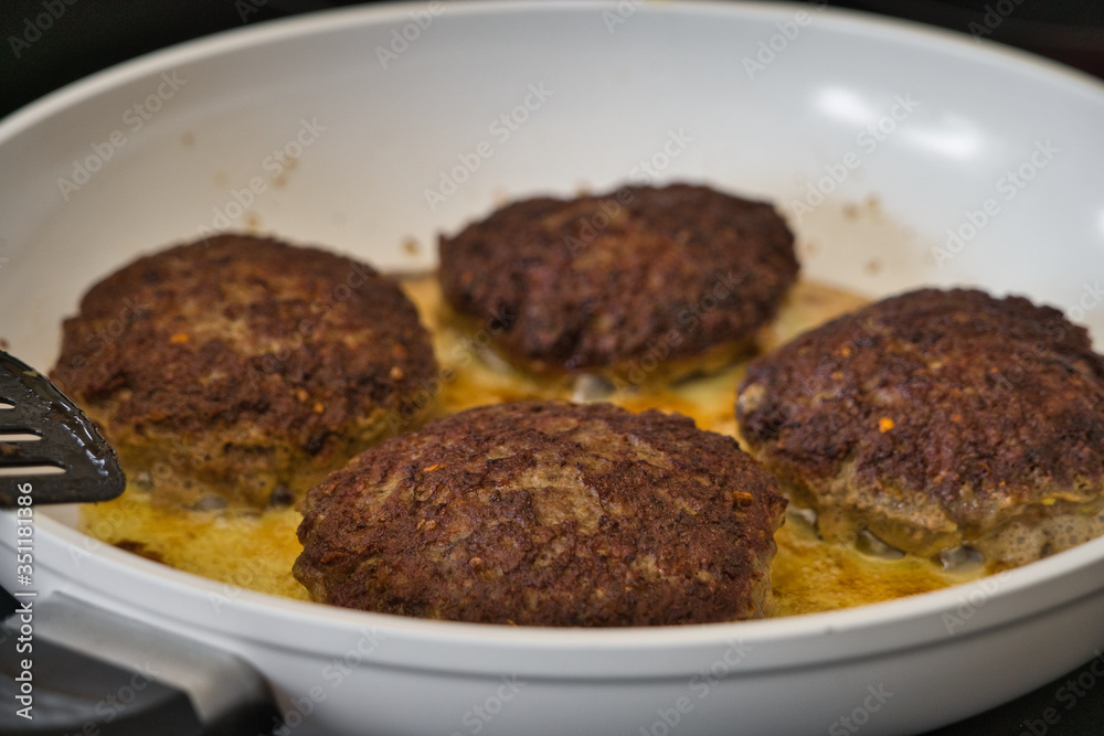 Frikadellen Gemüse Fleisch Paddys mit Kurkuma beim Anbraten in weißer Teflonpfanne mit Kokosöl, Produktbild Frikadellen Gemüse Fleisch Paddys mit Kurkuma beim Anbraten in weißer Teflonpfanne mit Kokosöl, Produktbild