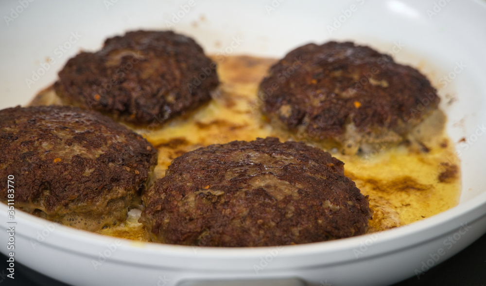 Frikadellen Gemüse Fleisch Paddys mit Kurkuma beim Anbraten in weißer Teflonpfanne mit Kokosöl, Produktbild Frikadellen Gemüse Fleisch Paddys mit Kurkuma beim Anbraten in weißer Teflonpfanne mit Kokosöl, Produktbild