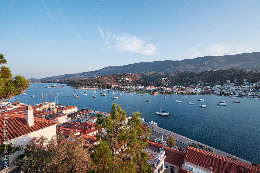 Scenic view of Poros island in summer day. Old town with traditional white houses near the sea. Saronic gulf, Greece, Europe.