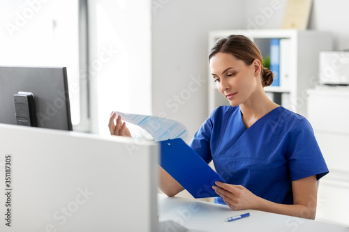 medicine, technology and healthcare concept - female doctor or nurse with clipboard working at hospital © Syda Productions