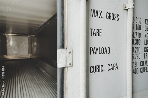 Fototapeta Naklejka Na Ścianę i Meble -  detail of white open door empty shipping cargo container for transportation shipping and logistic with copy space at container cargo harbor, industrial, logistics import and export business concept