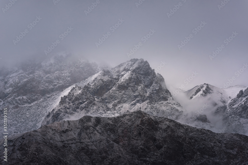 Obraz premium View of snow mountain surrounded by clouds with morning fog