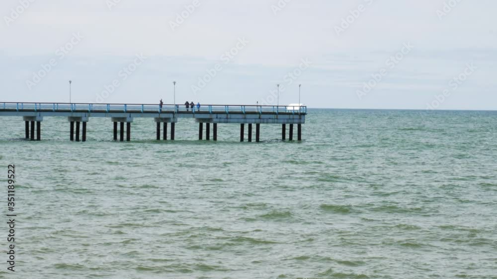 Palanga bridge to the Baltic sea while people walking on it in the distance. Palanga bridge to the Baltic sea while people walking on it in the distance.