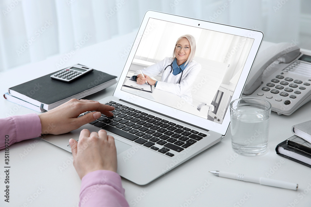 Woman using laptop for online consultation with mature female doctor, closeup Woman using laptop for online consultation with mature female doctor, closeup
