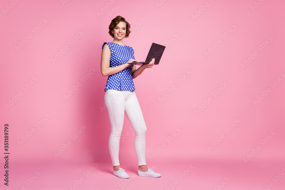 Full length body size view of her she nice-looking attractive lovely cheerful cheery wavy-haired girl holding in hands laptop preparing finance report review isolated on pink pastel color background Full length body size view of her she nice-looking attractive lovely cheerful cheery wavy-haired girl holding in hands laptop preparing finance report review isolated on pink pastel color background