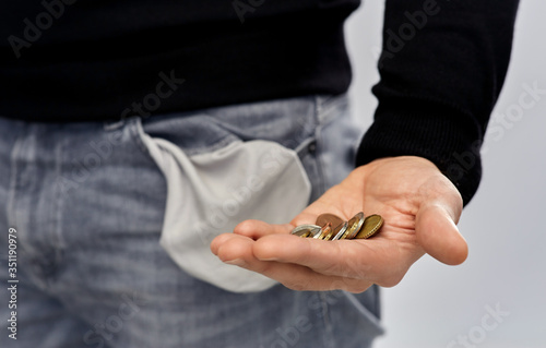 bankruptcy  financial crisis and poverty concept - close up of man showing hand with euro money coins and empty pockets over grey background
