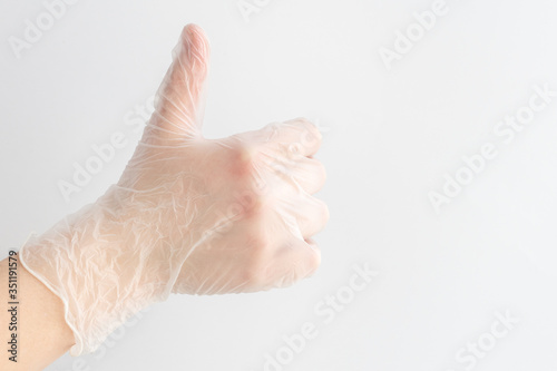 gesture thumb up, made by hand in medical glove on white background, communication skills, sign that means like.