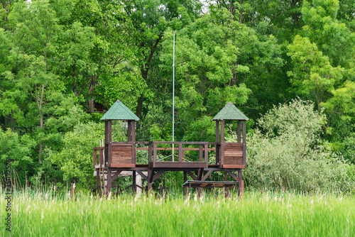 Wooden house in nature for hunters and bird photographers. Hunting watchtower. Wooden lookout tower for birdwatchin photo