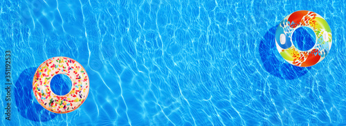 Different inflatable rings floating in swimming pool, top view. Banner design