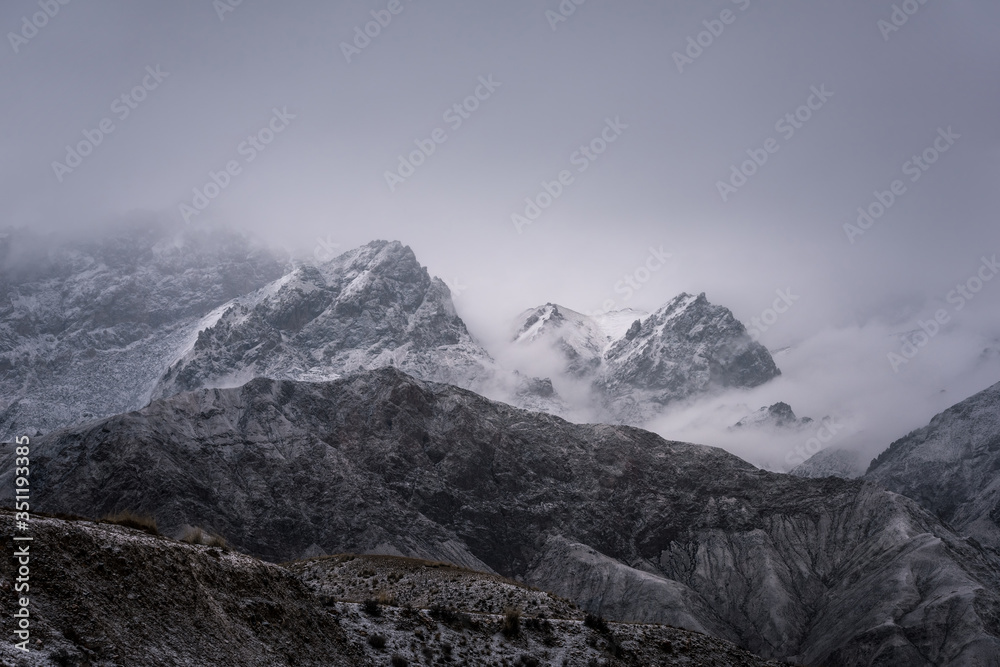 Obraz premium View of snow mountain surrounded by clouds with morning fog