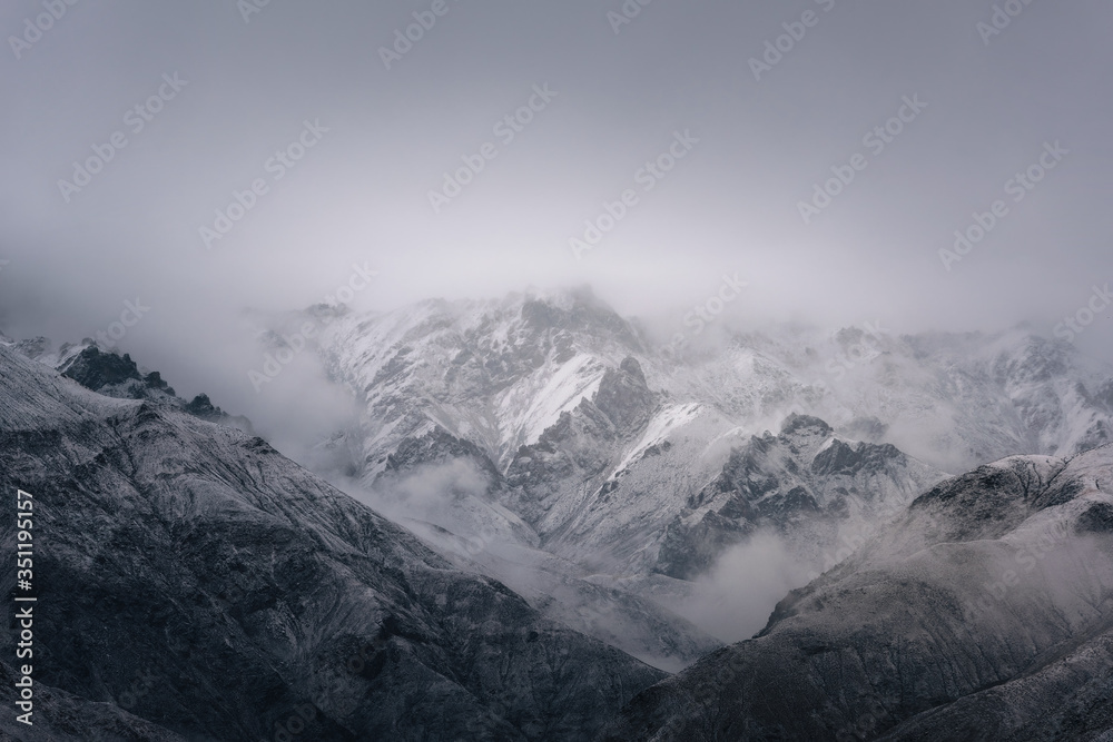 Fototapeta premium View of snow mountain surrounded by clouds with morning fog
