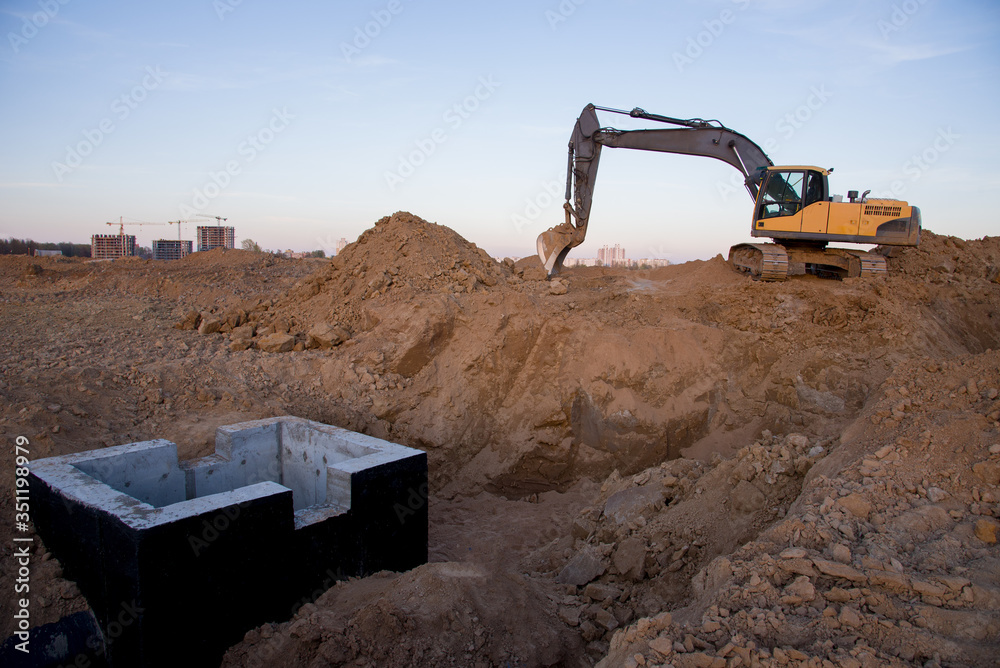 Excavator working at construction site on earthworks. Backhoe digs ...