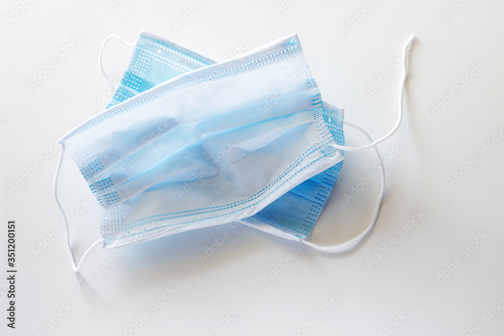 two used blue and torn masks on a white background
