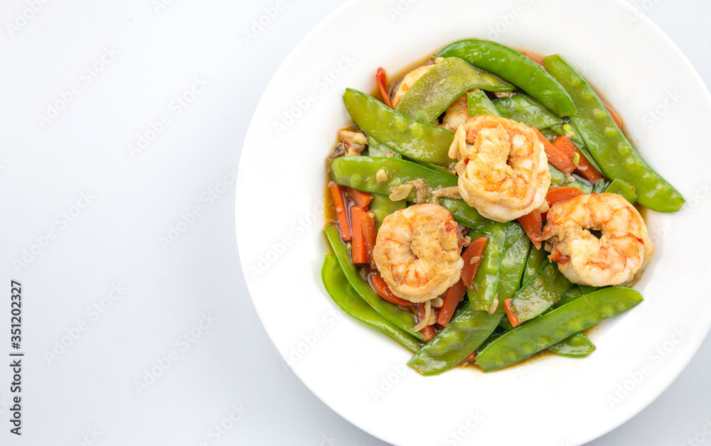 Stir-fried peas, put shrimp in a white plate on a white background. Stir-fried peas, put shrimp in a white plate on a white background.