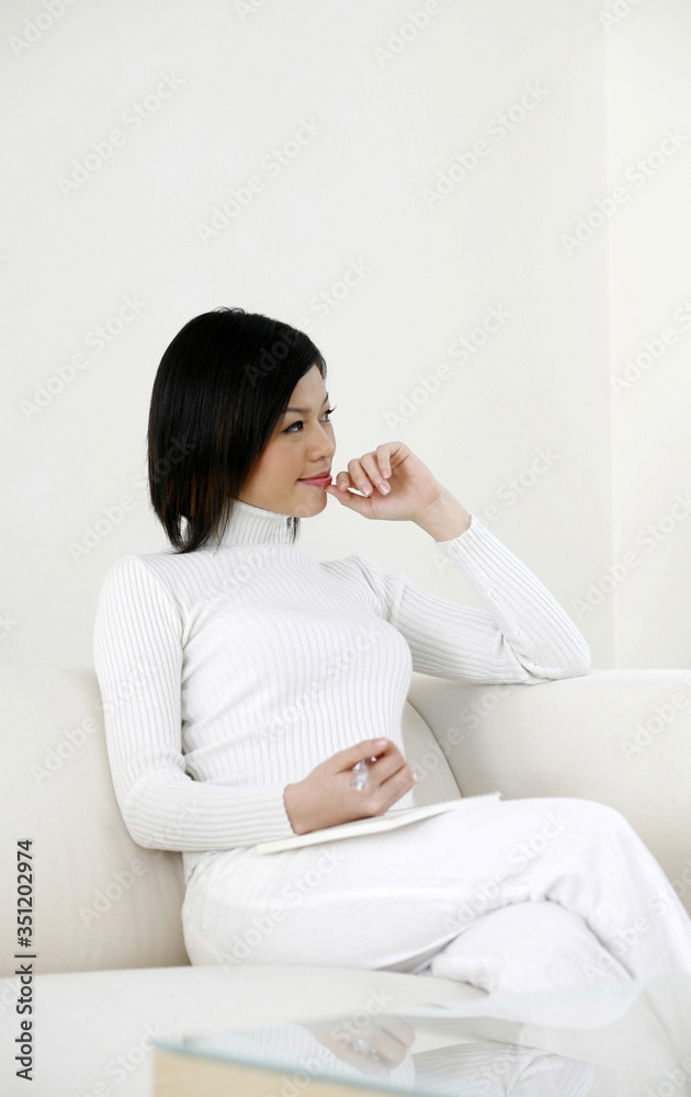 Woman thinking before writing in her notepad Woman thinking before writing in her notepad