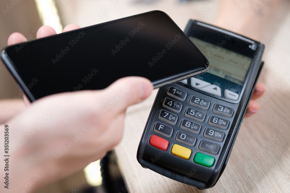 Hand and mobile payment in coffee shop ,mobile payment concept Hand and mobile payment in coffee shop ,mobile payment concept