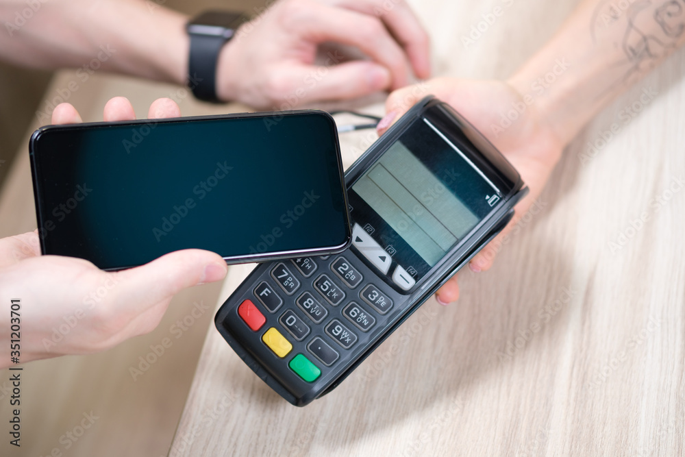 Hand and mobile payment in coffee shop ,mobile payment concept Hand and mobile payment in coffee shop ,mobile payment concept