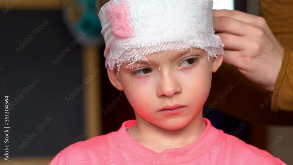 mother bandages the child's head. dressing an injured child's head. A