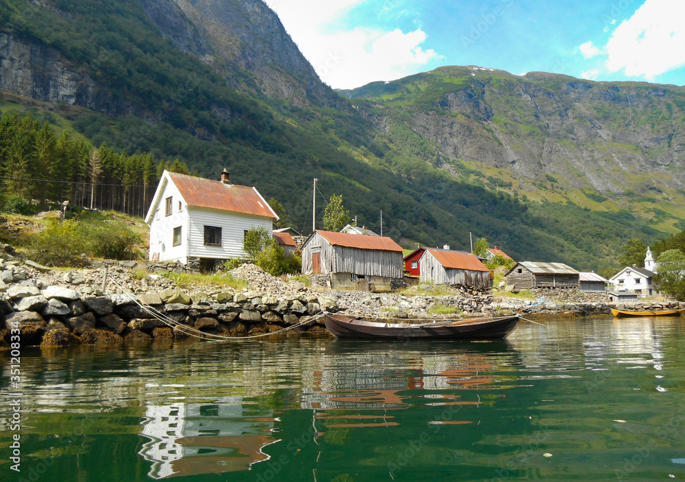 Houses on the edge of Norwegian fjord with reflections