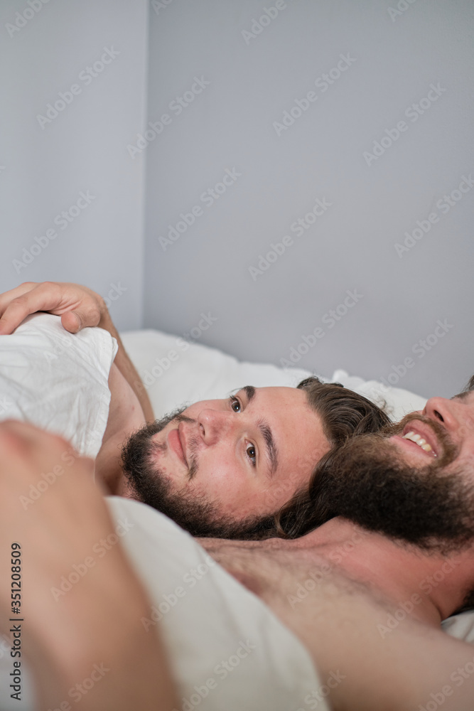Two men in bed laying together Two men in bed laying together