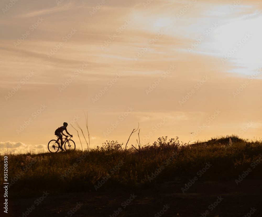 Fototapeta premium A cyclist pedals during the sunset in Madrid. Spain