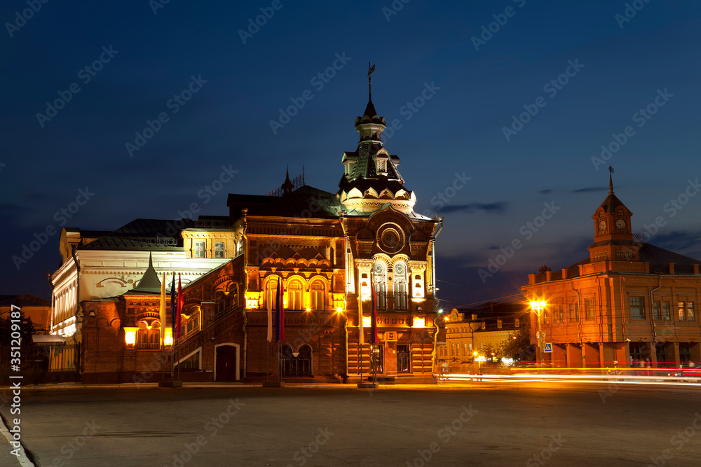 Fototapeta premium Sobornaya square with the building of the former city Duma, an architectural monument of the early 20th century and the new building of Sberbank at night. Vladimir, Russia