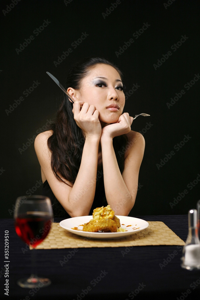 Woman with table knife and fork posing for the camera Woman with table knife and fork posing for the camera