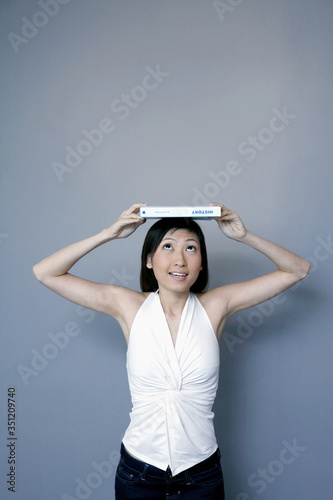 Woman balancing book on her head