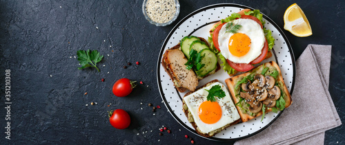 Different sandwiches on a black background. Tasty healthy appetizer with avocado. Quick breakfasts. Healthy eating concept. Proper nutrition. Top view. Banner.