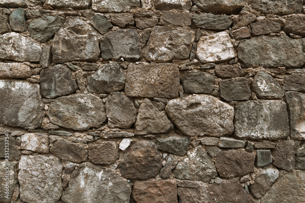 Textured background of cobblestones. Background of shabby wall of old building with various shape stones Textured background of cobblestones. Background of shabby wall of old building with various shape stones
