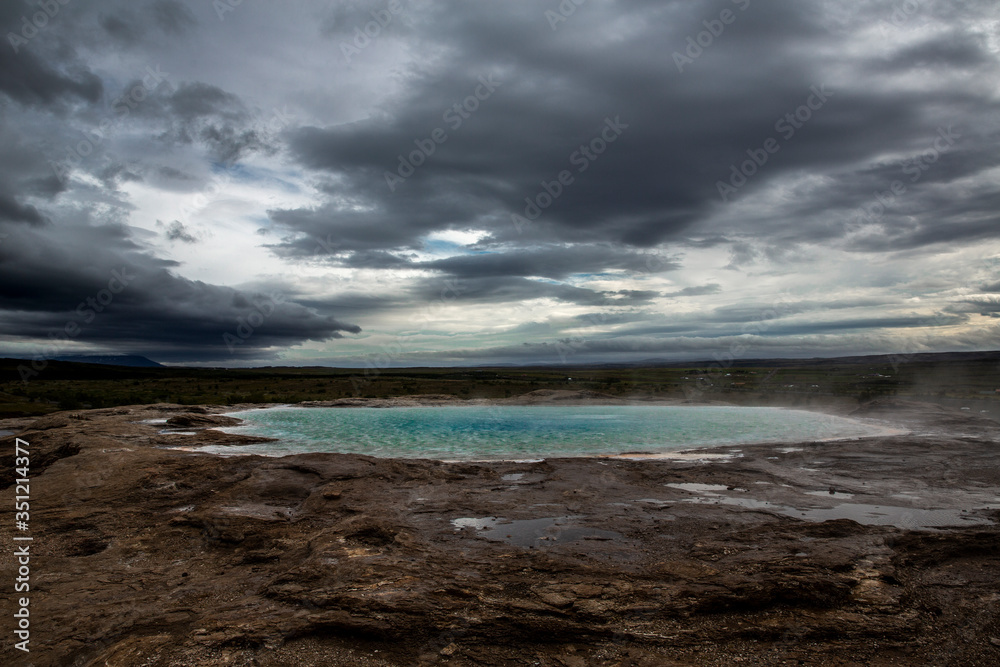 hot spring at the Geysir site in central Iceland. The water is heated by geothermal energy and gives off a slight egg-like smell from the sulfur rising from the earth