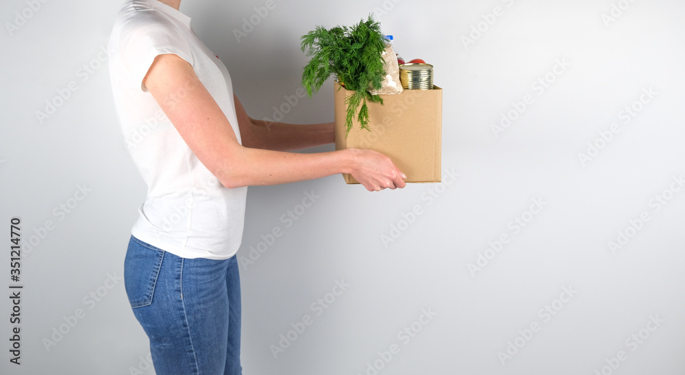 .Young girl holding box with donations on grey background. .Young girl holding box with donations on grey background.