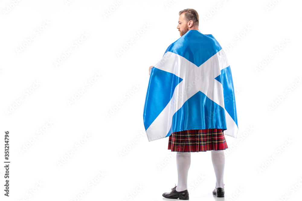 back view of Scottish redhead man in red kilt with flag of Scotland on white background