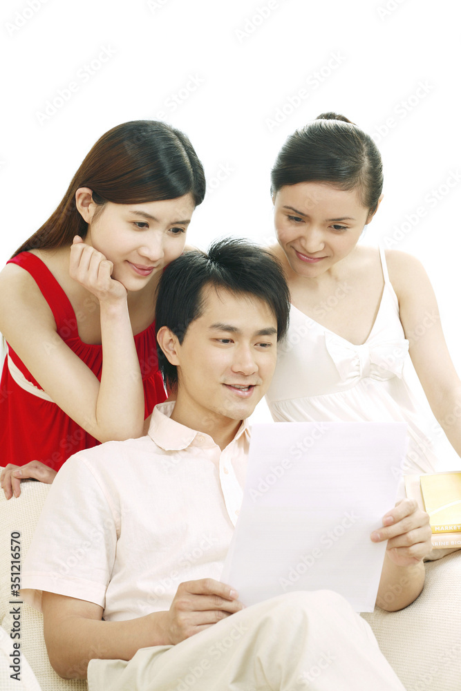 Man and two women looking at paper Man and two women looking at paper