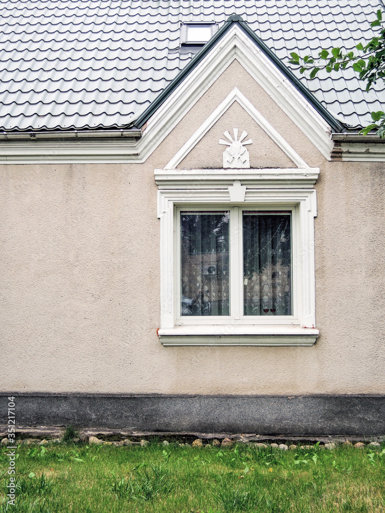 A white gabled window in a beige wall, vilnius, lithuania A white gabled window in a beige wall, vilnius, lithuania