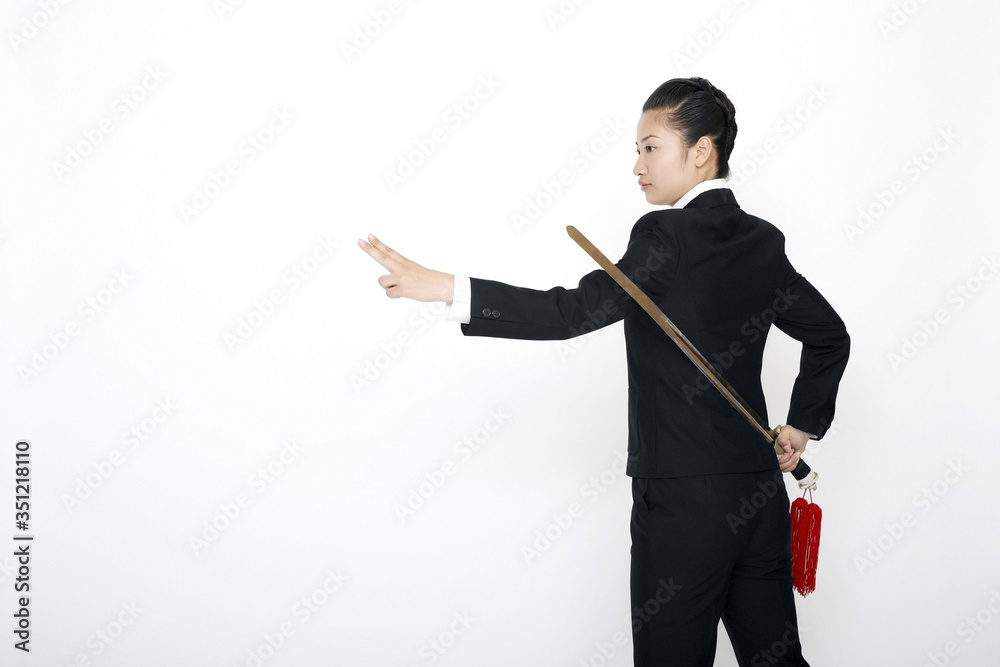 Businesswoman practising martial arts with a sword Businesswoman practising martial arts with a sword