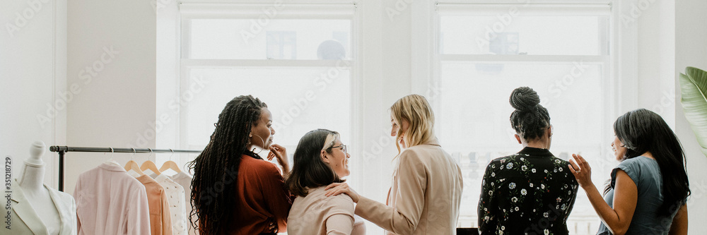 Happy female fashion designers working together Happy female fashion designers working together