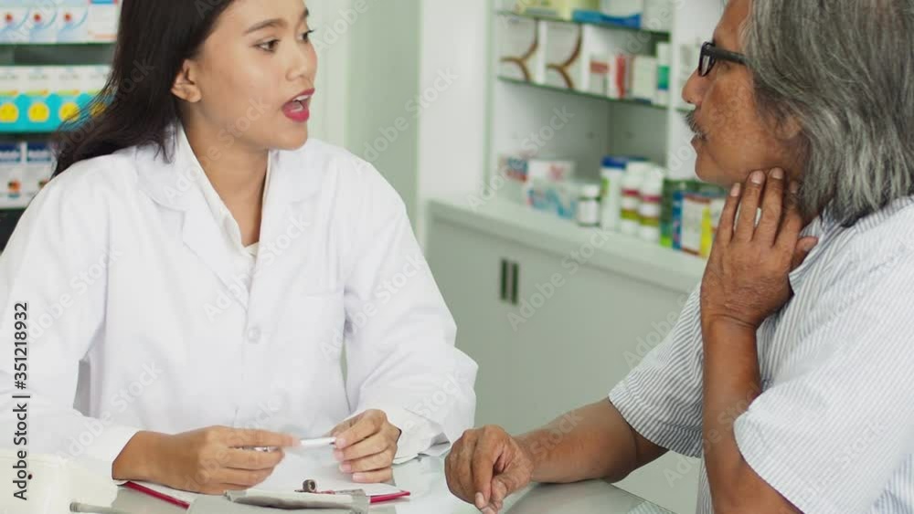 Beautiful asian Pharmacist counseling medication to patient in drug store