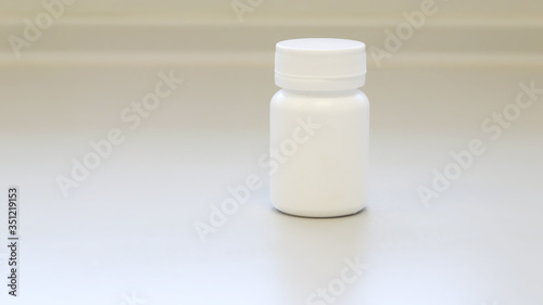 Mock up white medicine bottle or jar with cap template isolated in white medical room background, medicine packaging for medication pills, tablets, capsules drug pharmaceutical or Supplement vitamin.