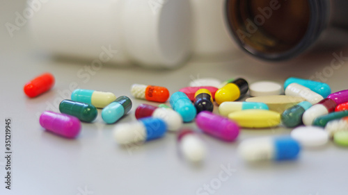 White and Brown glass medicine bottles with colorful tablets, pills, capsules drugs using for treatment and cure the disease or sickness. Drug prescription for medication isolate in white background.