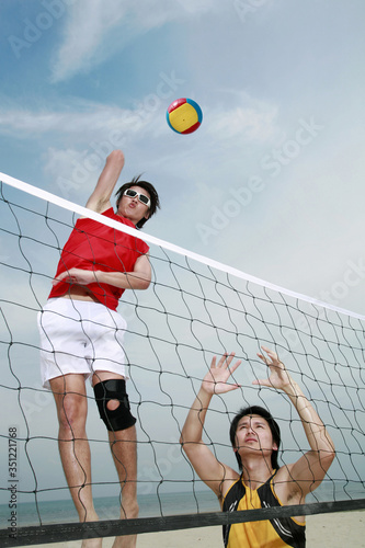 Men playing beach volleyball