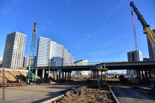 Work of truck crane and crawler crane on bridge project works. Roundabout traffic bridge construction and highway ramps. Road work on traffic highway, road intersection junction and freeway