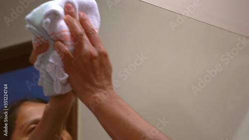 Wallpaper Mural Hispanic woman cleaning mirror in bathroom Torontodigital.ca
