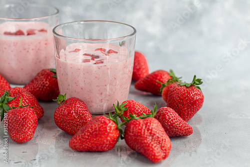 Strawberry and yogurt smoothies on a gray background. Decorated with elderberry flowers and strawberries. Healthy nutrition, diet.