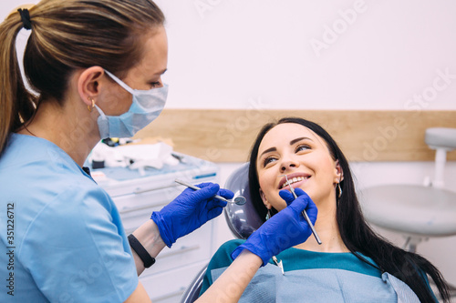 Young attractive brunette girl at the dentist consultation. Checking and dental treatment in a dental clinic.