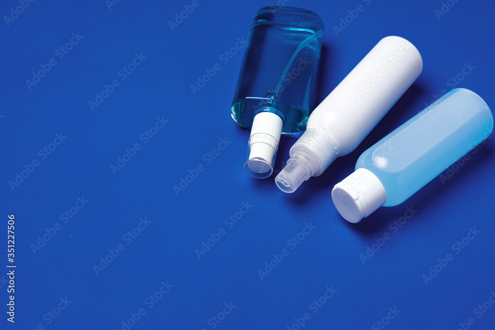 Bottles with antibacterial hand sanitizer on blue background with copy space Bottles with antibacterial hand sanitizer on blue background with copy space
