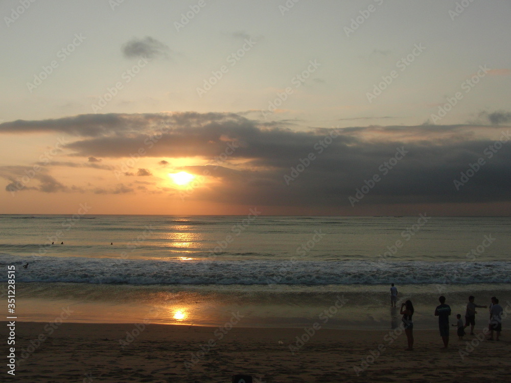 the sun sets on the horizon of the sea coast