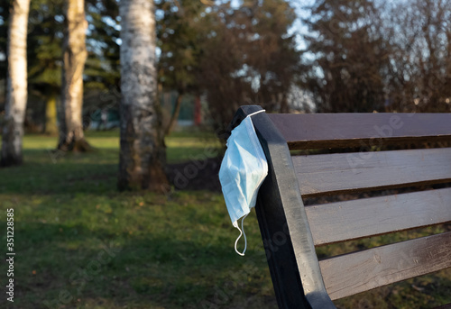 Removal of restrictive measures related to quarantine. A protective mask is left on the bench.