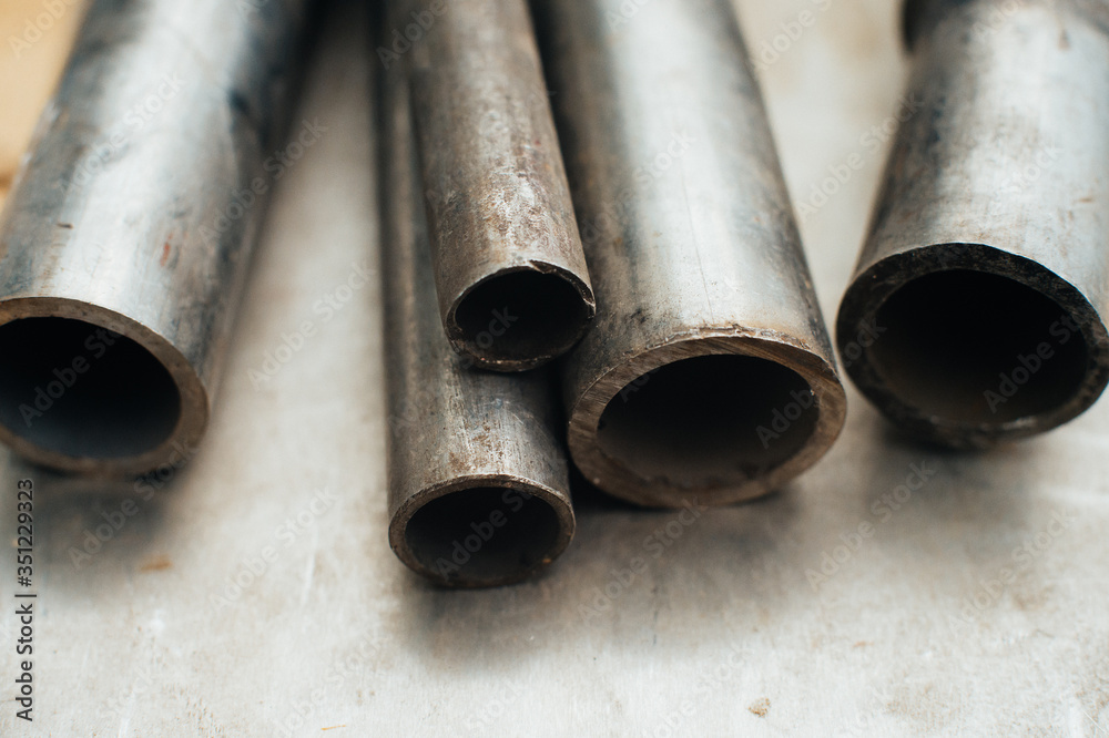 Stainless steel scrap metal, stainless steel pipes on the background of a stainless steel sheet. Close-up. Macro. Stainless steel scrap metal, stainless steel pipes on the background of a stainless steel sheet. Close-up. Macro.